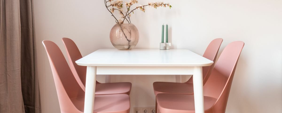 une table blanche avec des chaises roses
