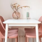 une table blanche avec des chaises roses